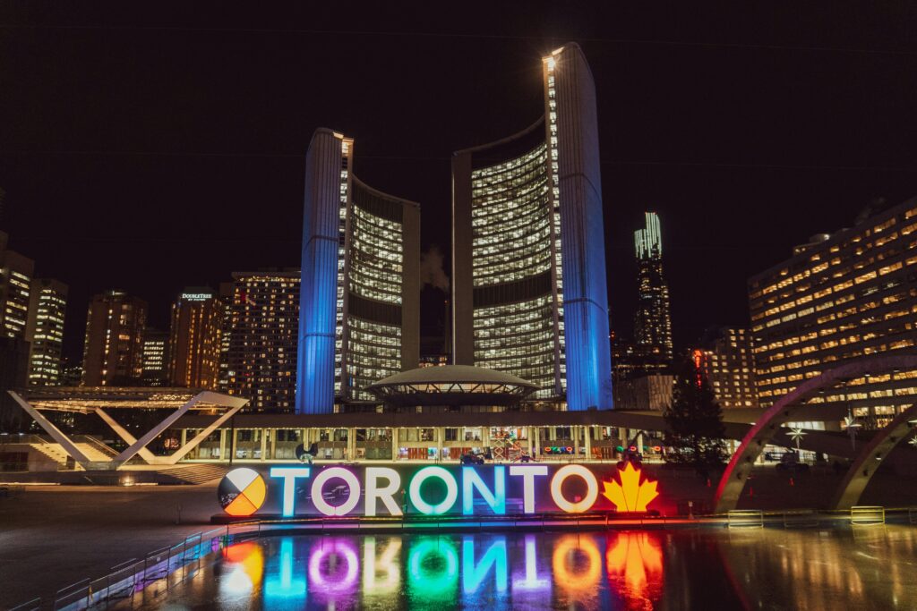 Scholarships in Canada for international students. A nighttime view of the glowing "TORONTO" sign at Nathan Phillips Square.