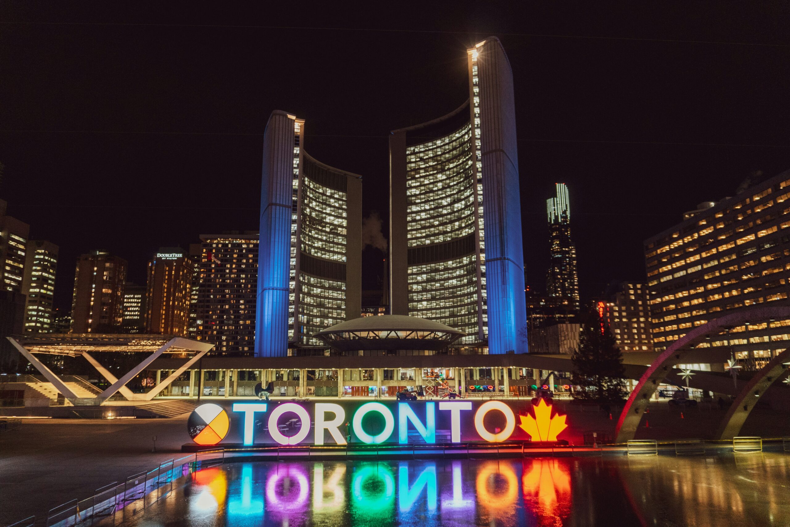 Scholarships in Canada for international students. A nighttime view of the glowing "TORONTO" sign at Nathan Phillips Square.